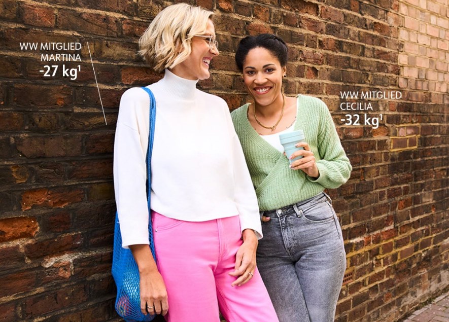 Two happy women bonding together and one is holding a beverage