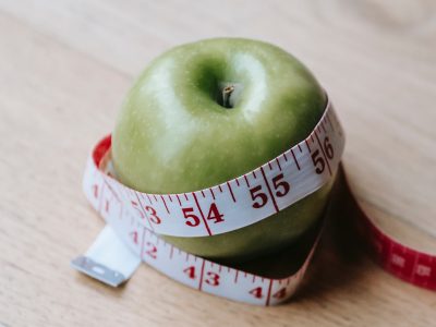 Picture of a green apple wrapped by a measuring tape